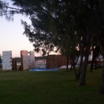 What appears to be pieces of the castle facade, a town or a house, being prepared beneath the casuarinas